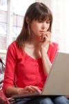 Worried Young Woman Using Laptop At Home