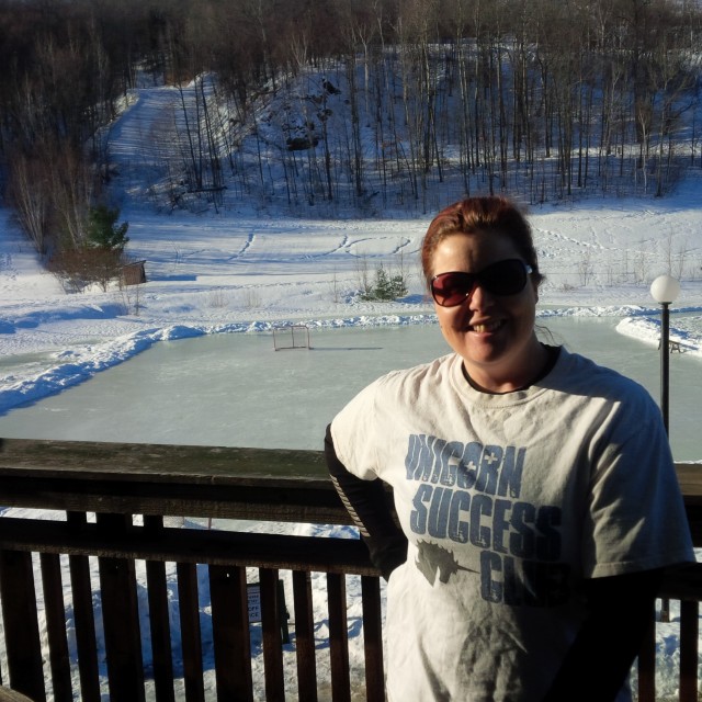 Enjoying some sun on the hotel room balcony. Check out the ice rink behind me!